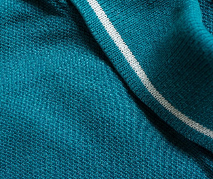 Green polo shirt texture, cotton fabric. Textile background